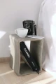 Concrete table used as a side table with a coffee cup, vintage camera, and a book.