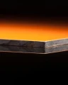 Close-up of HPL PLATE ORANGE thickness 6 mm (SAMPLE 50×50 MM) showing the edge and layers.