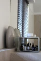 Concrete table with decorative vases and beauty products.